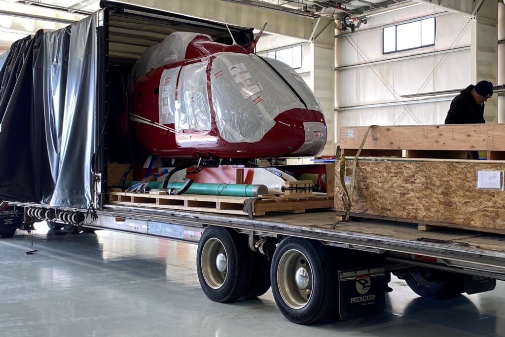 Bell 505 helicopter being transported — TransportWrap protects all vehicle types including aircraft