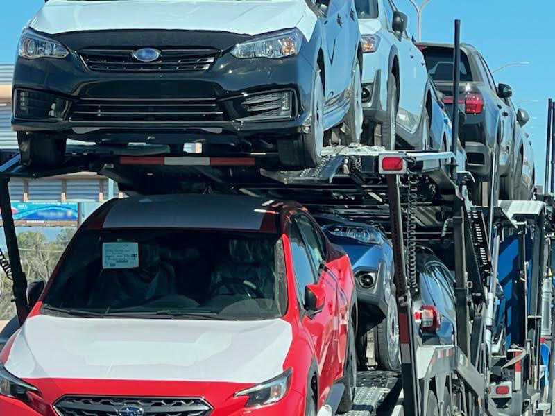 Vehicle on open auto carrier with TransportWrap protection applied